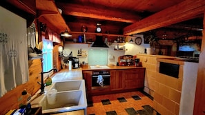 A kitchen with wooden cabinets, a sink, a stove, and various kitchen appliances.