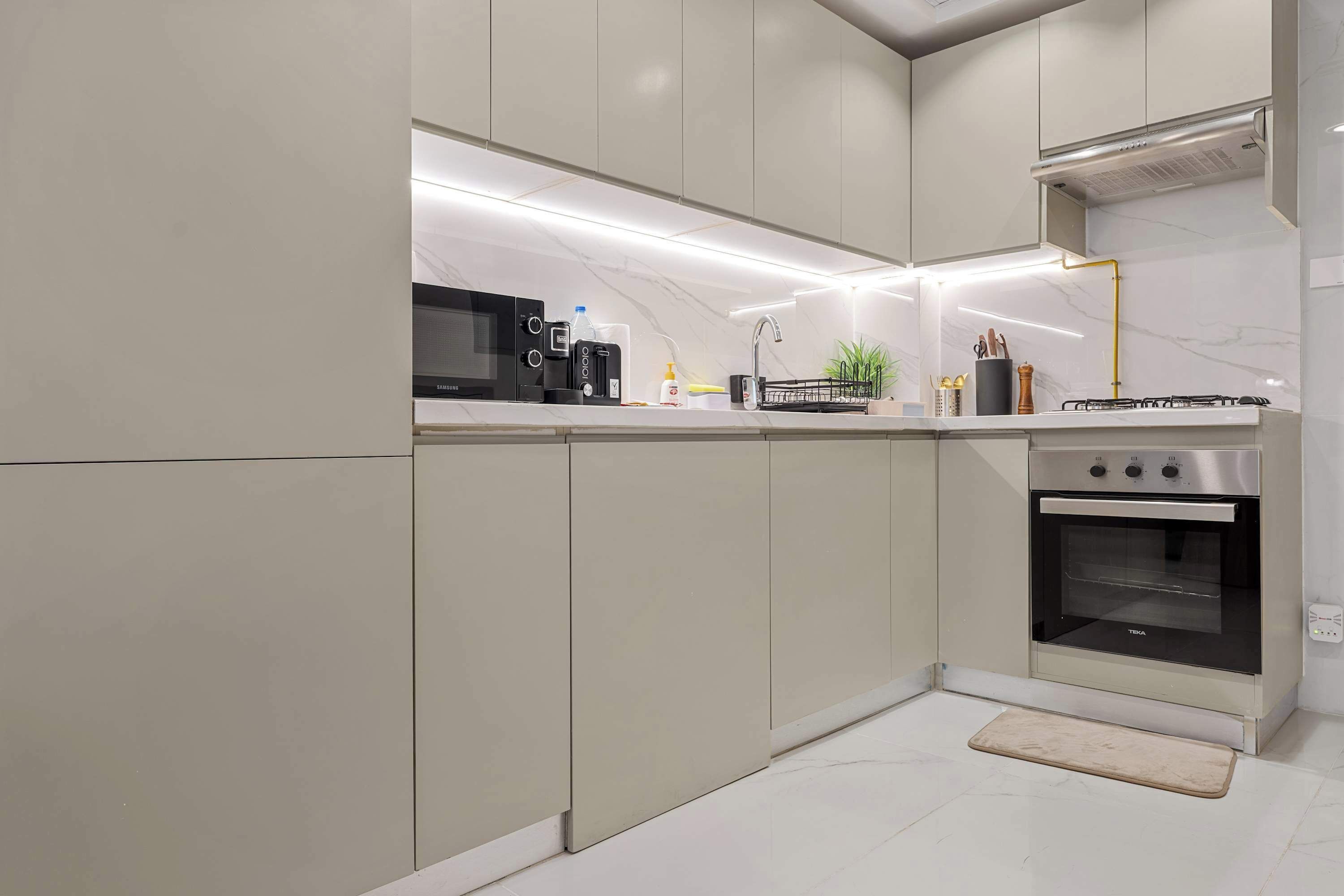 A modern kitchen with a built-in microwave, toaster, and oven, featuring a sleek design and ample counter space.