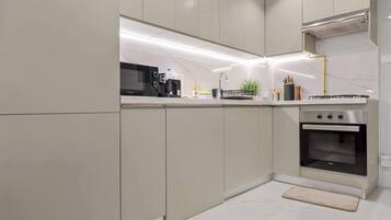 Una cocina moderna con microondas, tostadora y horno integrados, que presenta un diseño elegante y una amplia encimera.