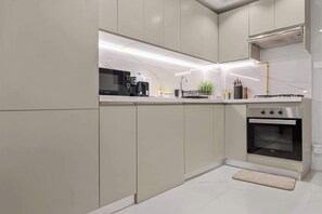 Een moderne keuken met een ingebouwde magnetron, broodrooster en oven, met een strak design en veel aanrechtruimte.