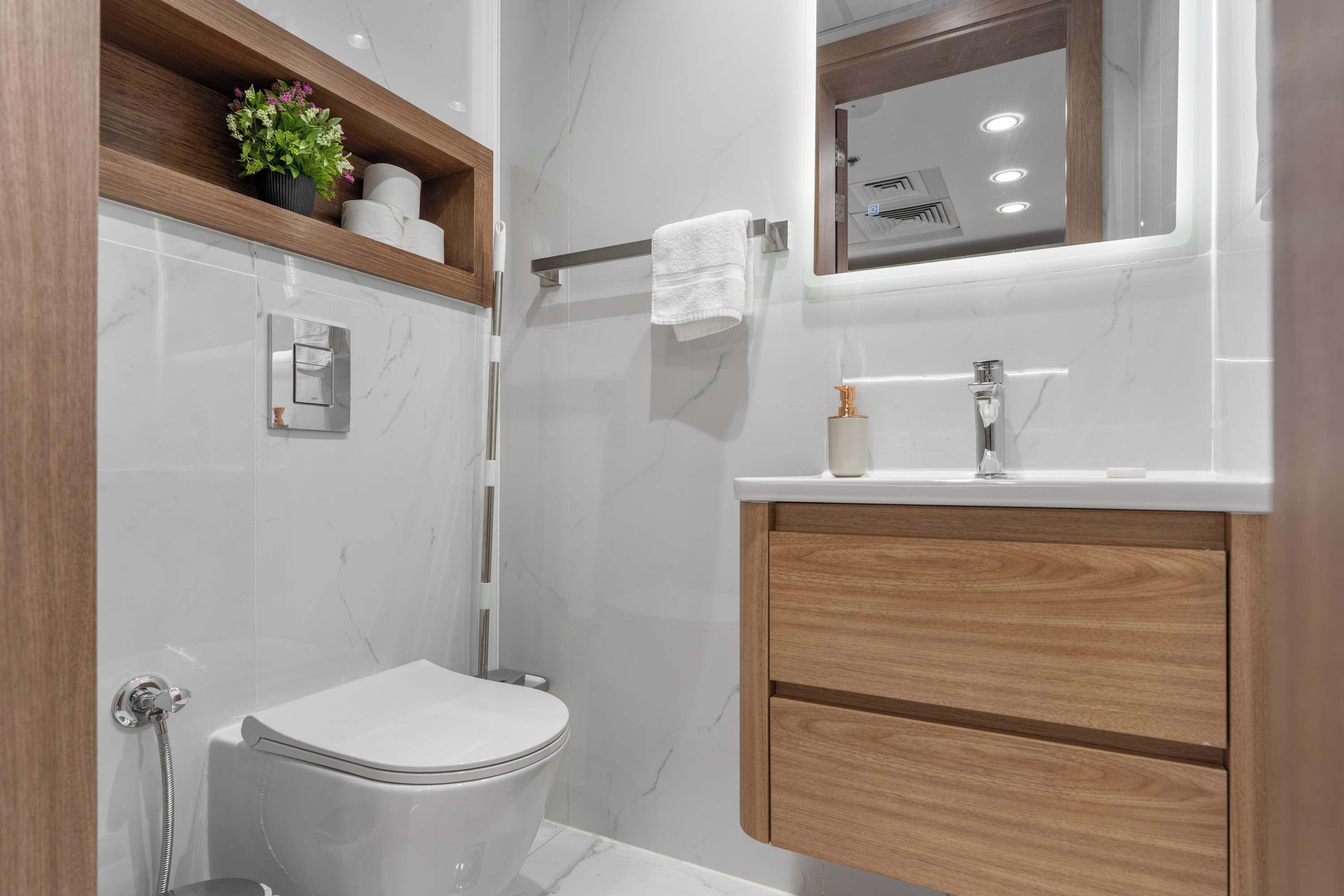 Ein modernes Badezimmer mit Toilette, Dusche, Waschtisch und Spiegel.