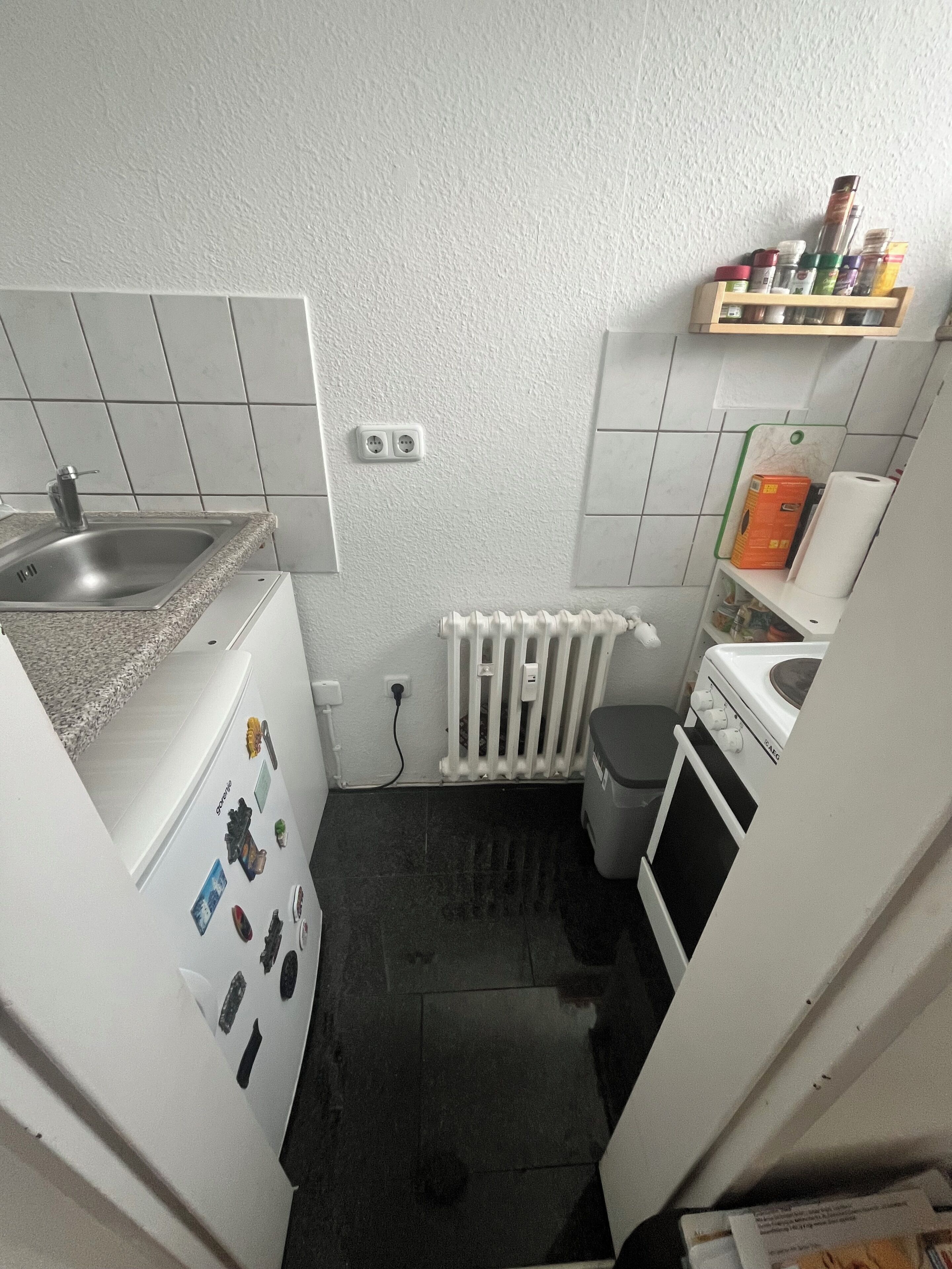 Eine kleine Küche mit Spüle, Herd und einer Arbeitsplatte.