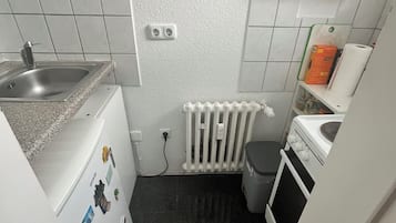 Eine kleine Küche mit Spüle, Herd und einer Arbeitsplatte.