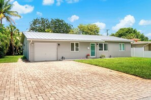 Eingeschossiges Haus mit Garage, Eingangstür und einer kleinen Veranda.