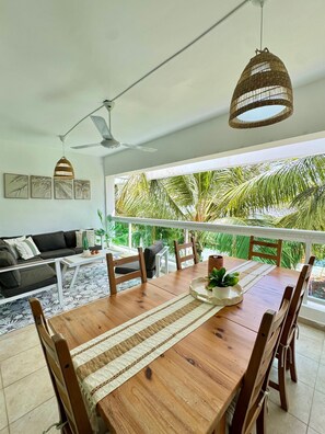 Un espace repas comprenant une table en bois, des chaises et un luminaire suspendu.