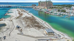 An aerial view of a coastal area with a marina, a large hotel, and a bridge. - 🌊Walk 2 Beach~2 Pools~Beautiful Views~2BR The Islander 314 🌊 (Destin)