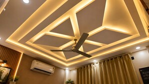 A ceiling with geometric lighting design, a ceiling fan, and an air conditioning unit. - Hotel Rai Regal (Varanasi)