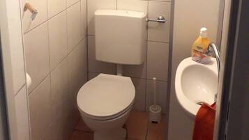 Ein kleines Badezimmer mit Toilette, Bidet und Waschbecken.