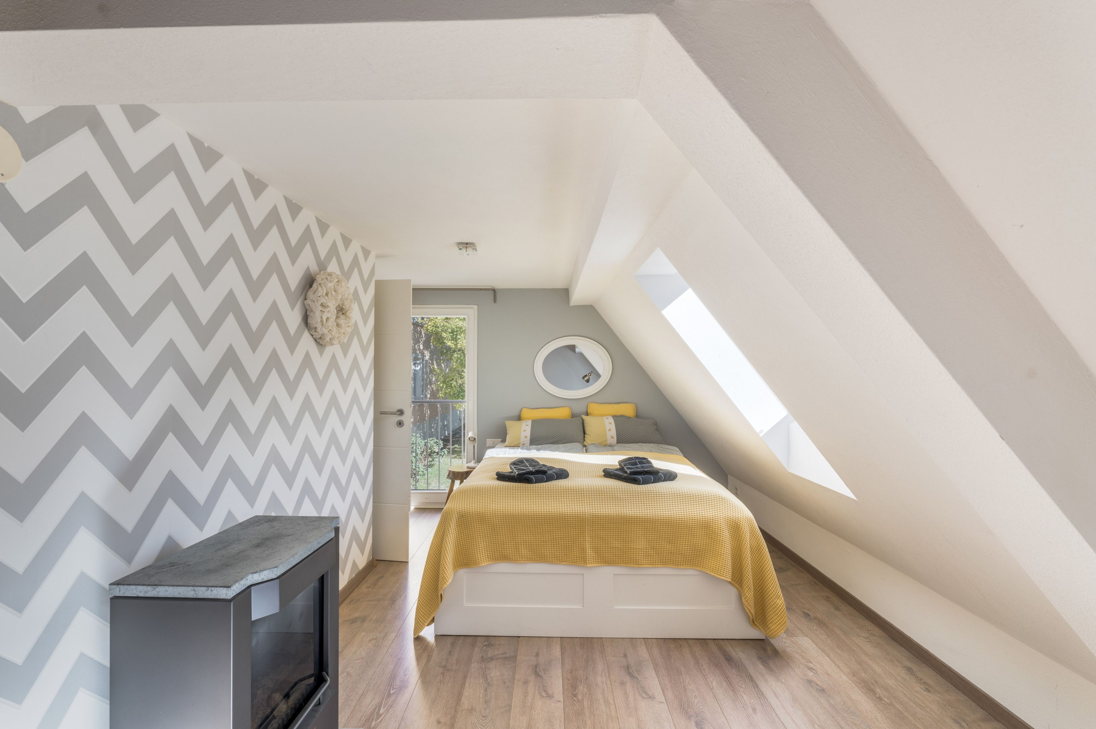 A bedroom with a bed, a small heater, and a window.