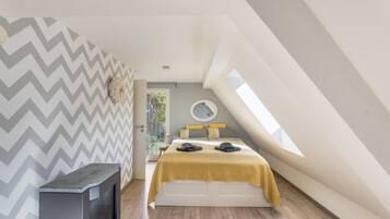 A bedroom with a bed, a small heater, and a window.