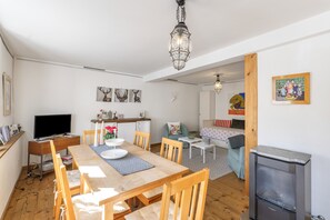 A cozy living room with a dining area, a fireplace, and artwork on the walls. - Holiday Home Alte Schusterei with Garden, Barbecue Area and Sun Loungers (Badenweiler)