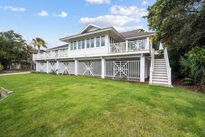 A two-story house with a covered porch and a fenced backyard. - Charming Oceanview Beach Retreat (Fripp Island)