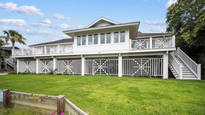 A two-story house with a covered porch and a staircase leading to the upper level.