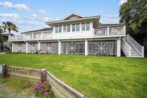 A two-story house with a covered porch and a staircase leading to the upper level. - Charming Oceanview Beach Retreat (Fripp Island)