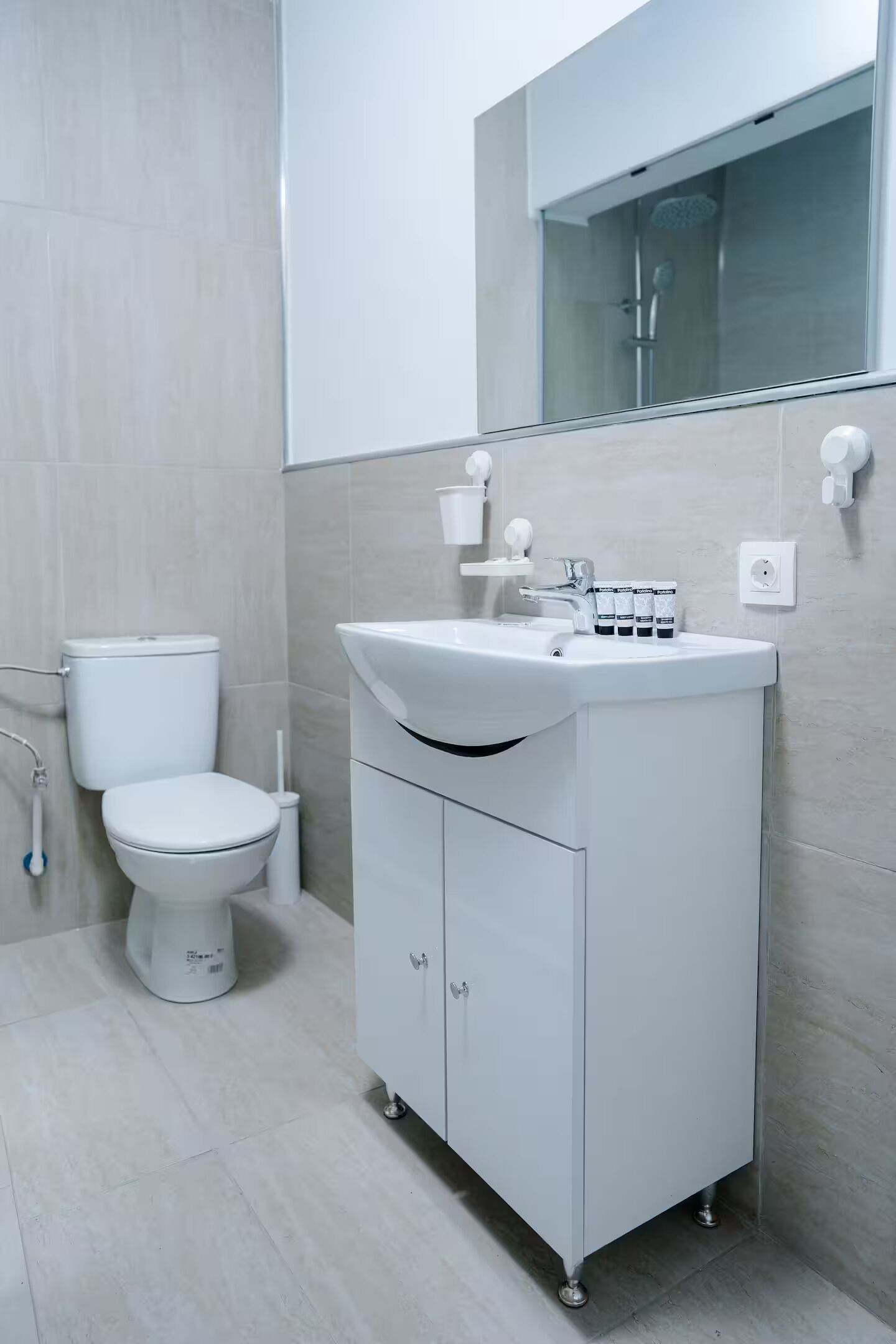 Une salle de bain moderne avec des toilettes, un lavabo et un miroir.