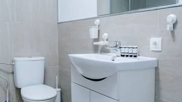Une salle de bain moderne avec des toilettes, un lavabo et un miroir.
