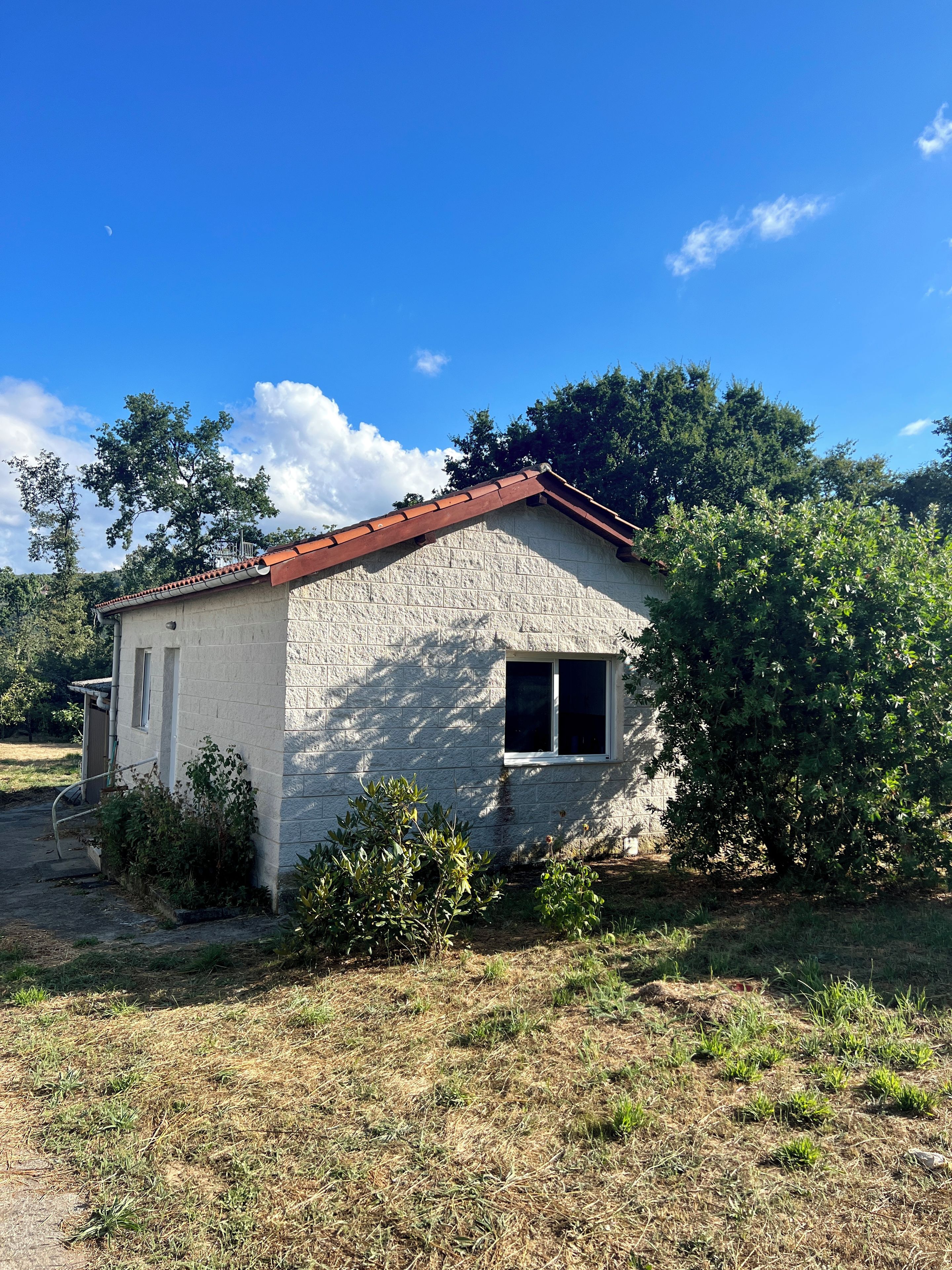 A small, single-story building with a sloped roof, a window, and a door.