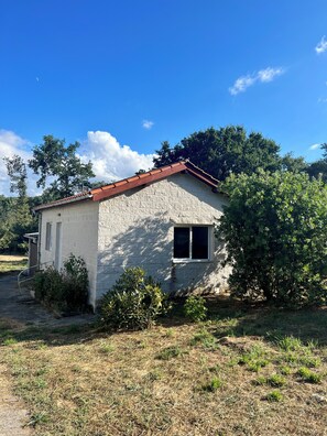 A small, single-story building with a sloped roof, a window, and a door. - Cozy House & Garden, A Pedreira Slow Living (Celanova)