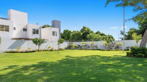 A modern building with a flat roof, large windows, and a well-maintained lawn.