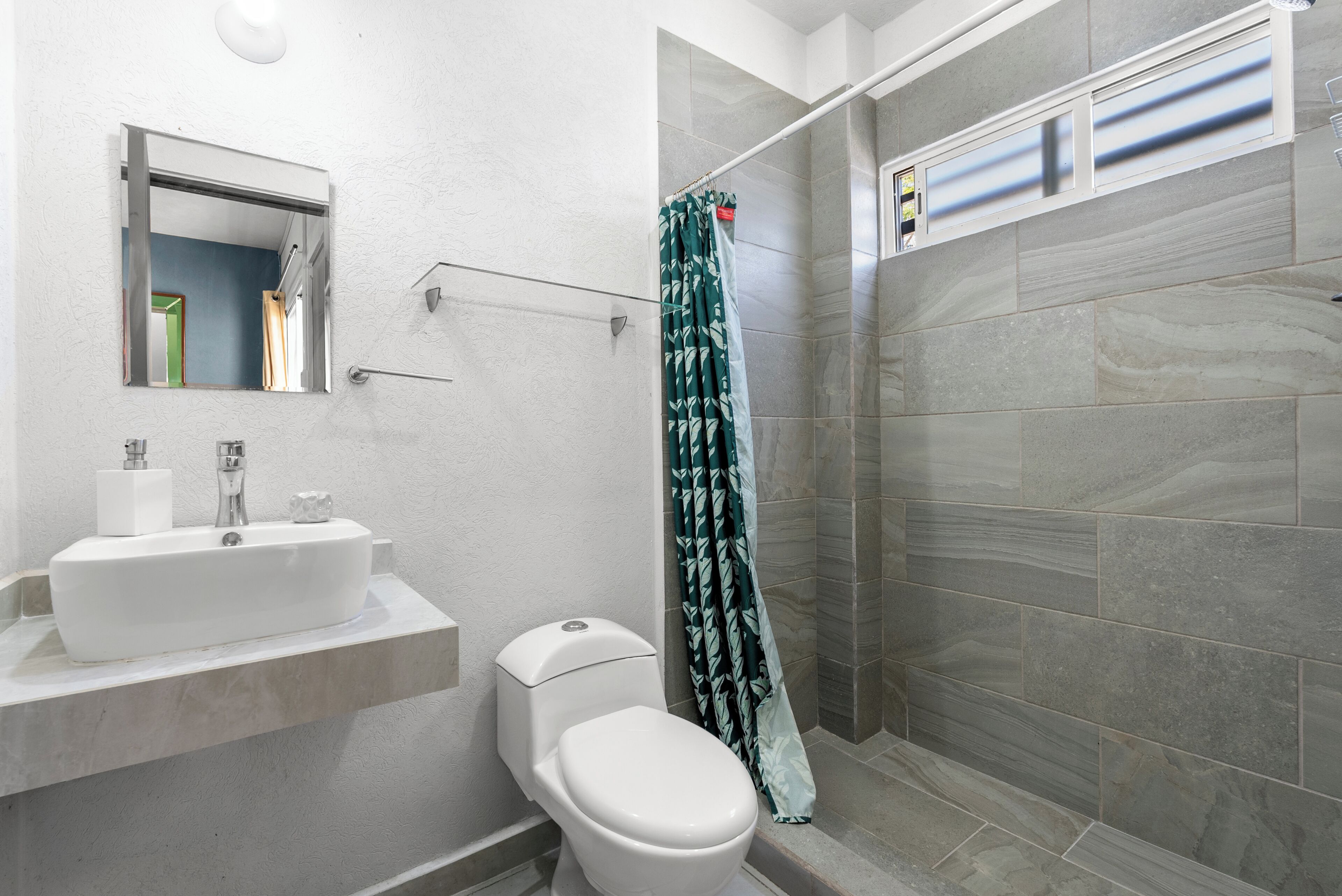 Un baño moderno con ducha, inodoro y lavabo.