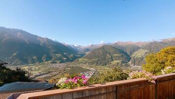 A balcony with a view of a valley and mountains.