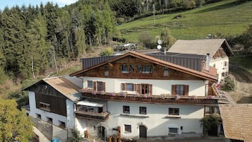 Un chalet traditionnel doté d’un toit à pente, de balcons en bois et de fondations en pierre.