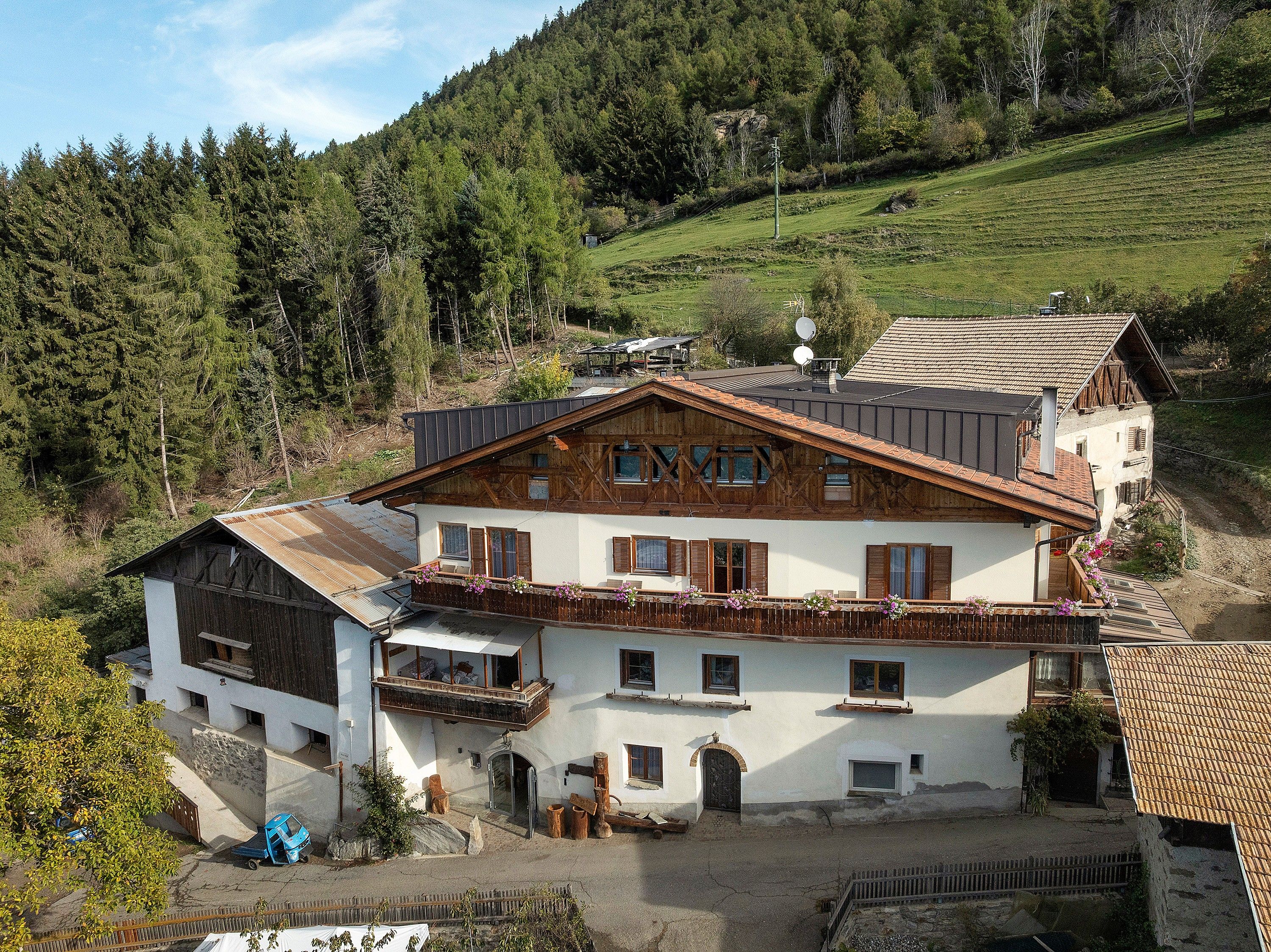 Un chalet traditionnel doté d’un toit à pente, de balcons en bois et de fondations en pierre.