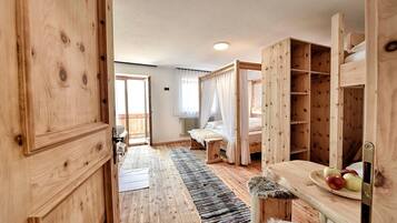 Ein Holzinnenraum mit einem Bett, einer Bank und einem Tisch mit Äpfeln.