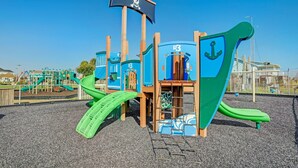 A playground with a pirate-themed play structure, including slides and climbing areas. - Ultimate Waterfront Escape | Pool, Dock, & Views (Jamaica Beach)