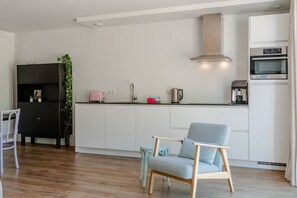 A modern kitchen with white cabinets, a stainless steel range hood, and a built-in oven. - Holiday home with 5 bedrooms in Ossenisse | Het Hoogland B (Ossenisse)