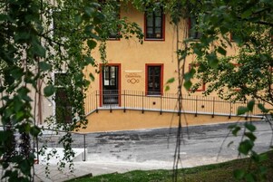 Un hotel con fachada amarilla, ventanas de marco rojo y un cartel que indica que es el HOTEL Cittadelloarte.
