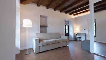 Un salon moderne avec un canapé, une lampe sur pied et un bureau avec une chaise.