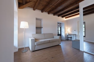 Una sala de estar moderna con un sofá, una lámpara de pie y un escritorio con una silla.