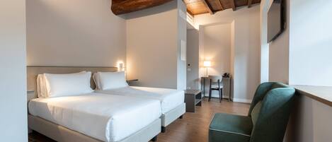 Een hotelkamer met een groot bed, een bureau, een stoel en een houten plafond.