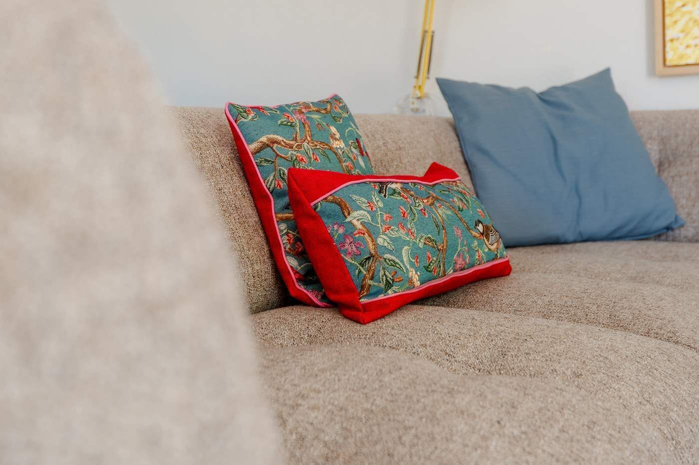 Un divano con due cuscini decorativi e un cuscino blu.