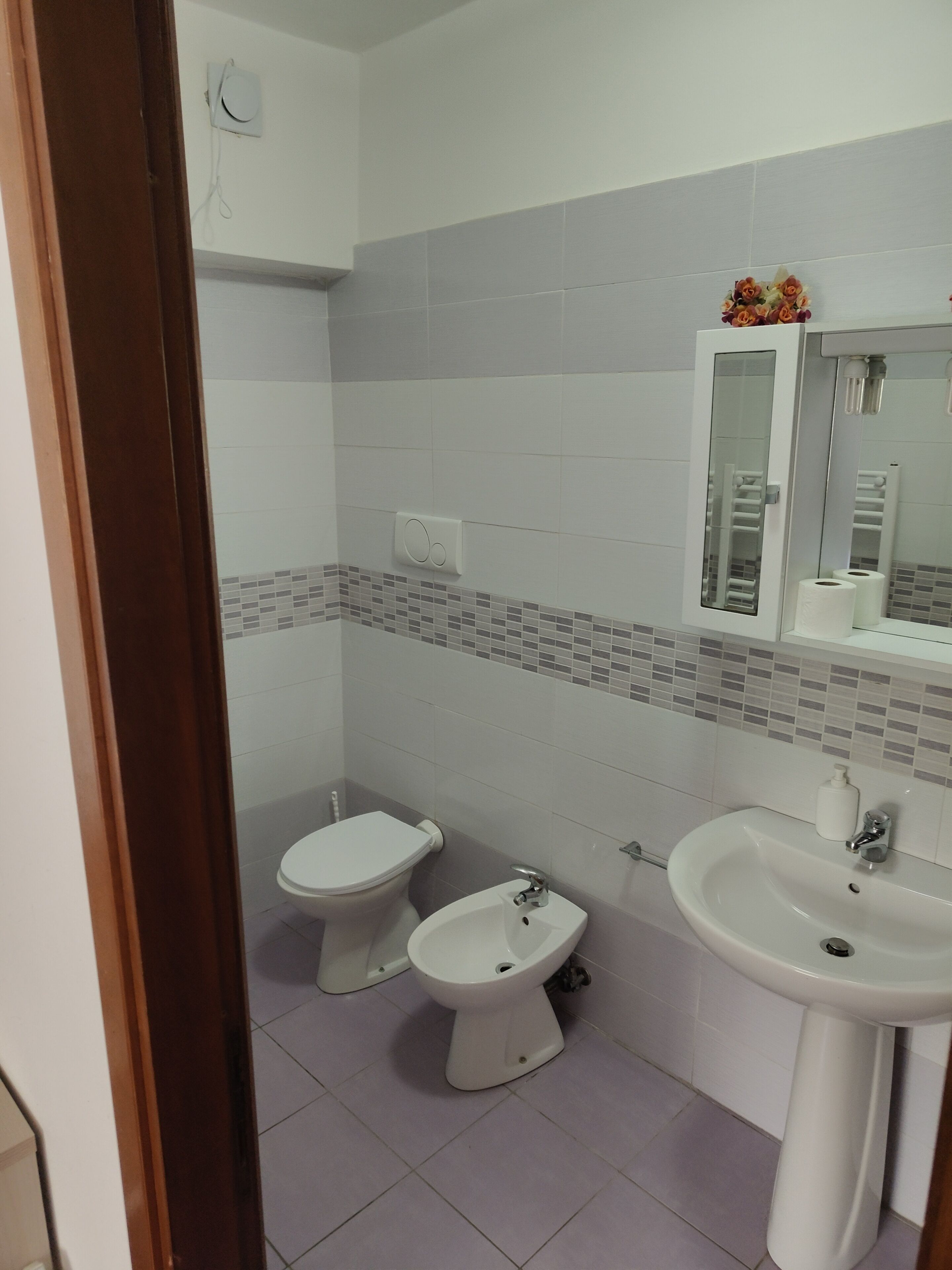 A bathroom with a toilet, bidet, and sink.