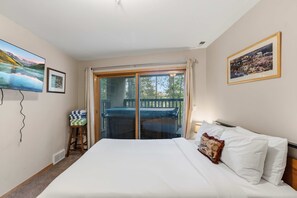 A hotel room with a bed, a small table with a chair, a TV, and a balcony with a view. - Breck Getaway | Walk to Slopes/Downtown + Hot Tub (Breckenridge)