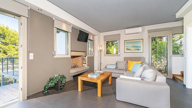 Ein stilvolles Wohnzimmer mit einer Couch, einem Couchtisch und einem Kamin.
