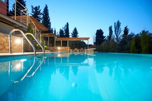A swimming pool with a clear blue water surface, surrounded by a stone wall and metal railings. - Villa Porphyra - Four Bedroom Villa, Sleeps 8 (Lefkada City)