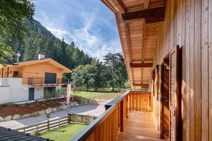 Una cabana de fusta amb un balcó que domina un paisatge de muntanya.