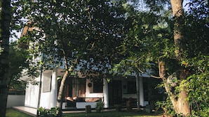 Um edifício com área de jardim, incluindo gramado e árvores.
