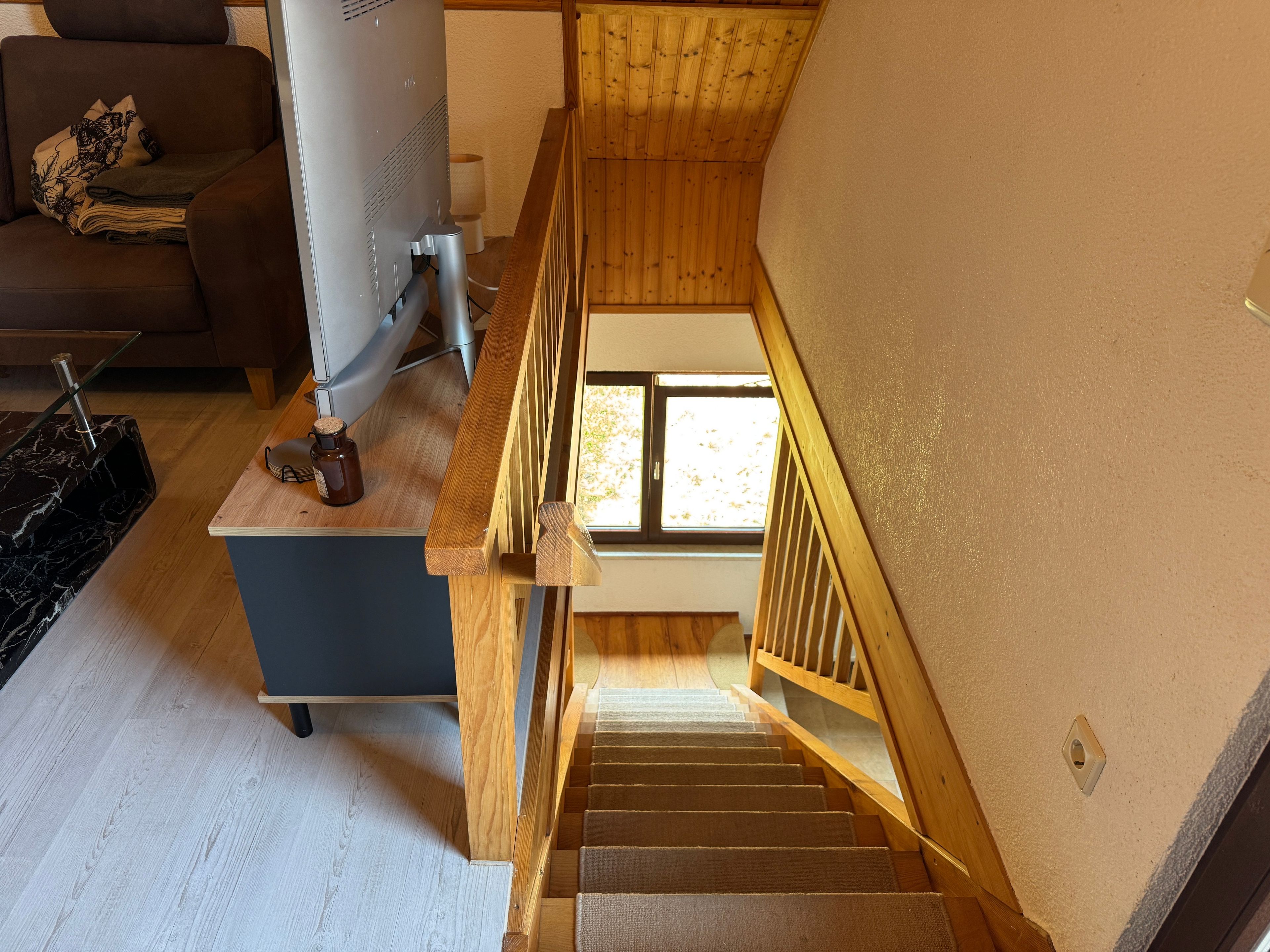 Un escalier avec des rampes en bois menant à l’étage supérieur.