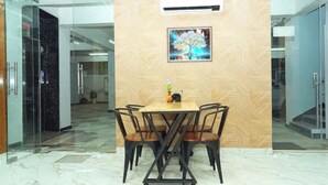 A meeting room with a wooden wall, a glass partition, and a table with chairs.