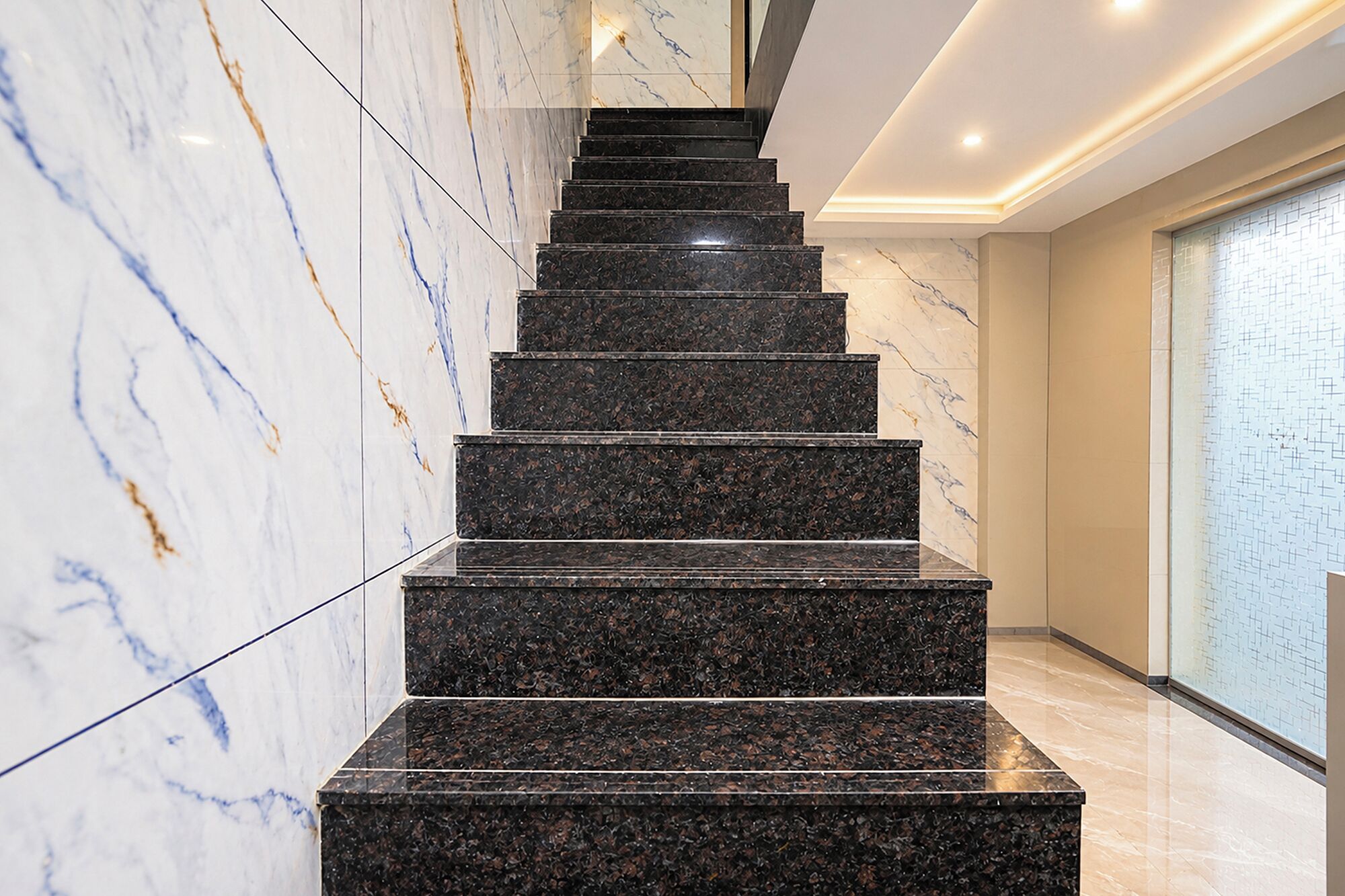 A marble staircase with a modern design, leading to a higher floor.
