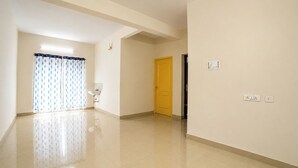 A hallway with a bathroom, a door, and electrical outlets.