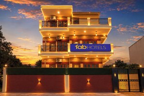 A multi-story hotel with a prominent sign reading 'fabHOTELS' and a gated entrance. - Fabhotel Maurya Residency (Gurugram)