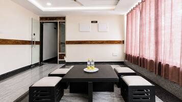 Un salón de conferencias con una mesa, sillas y un ventilador de techo.