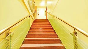 A staircase with a handrail and a green safety railing on both sides. - Fabhotel Ritz Residency (Jaipur)