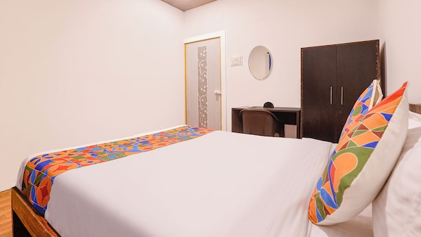 Un dormitorio con cama, escritorio, armario y puerta.