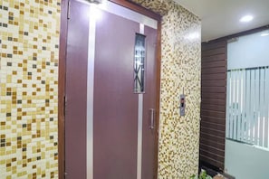 A room with a door, a window, and a wall with a mosaic pattern. - FabHotel Ashoka Palace (Bhopal)